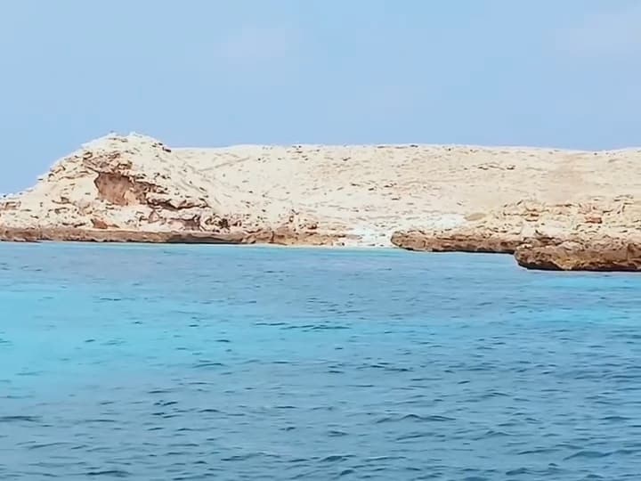 Pale limestone island of the Daymaniyat chain above turquoise sea