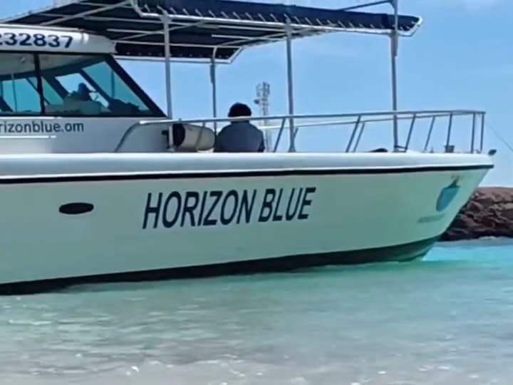 Horizon Blue boat resting in clear shallows at the Daymaniyat Islands